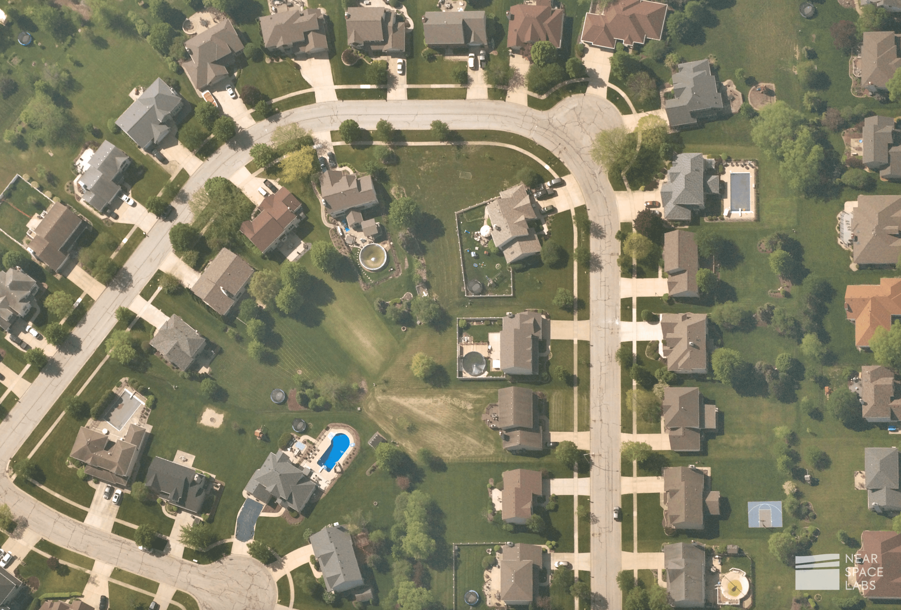 Residential community showcasing alligator cracking in roads, swimming pools, outside furniture, and surrounding landscapes.