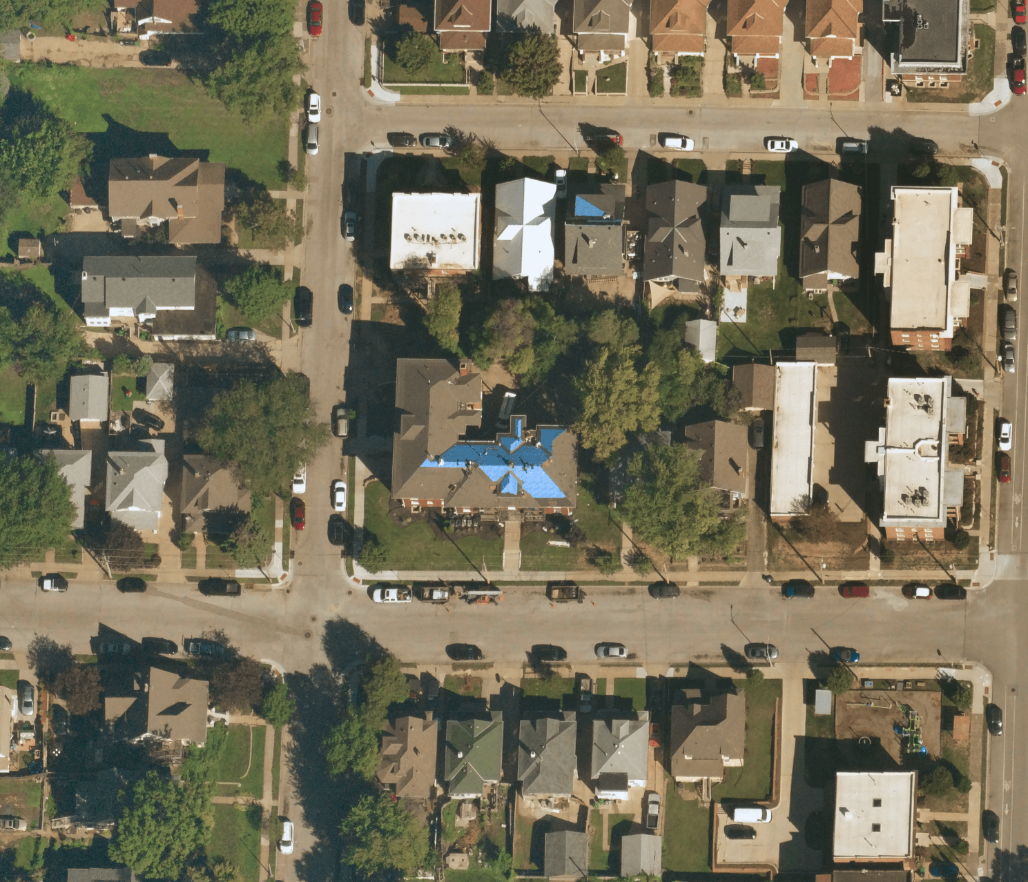 Near Space Labs' 10 cm capture of a neighborhood showing a property with a blue tarp indicating roofing damage.