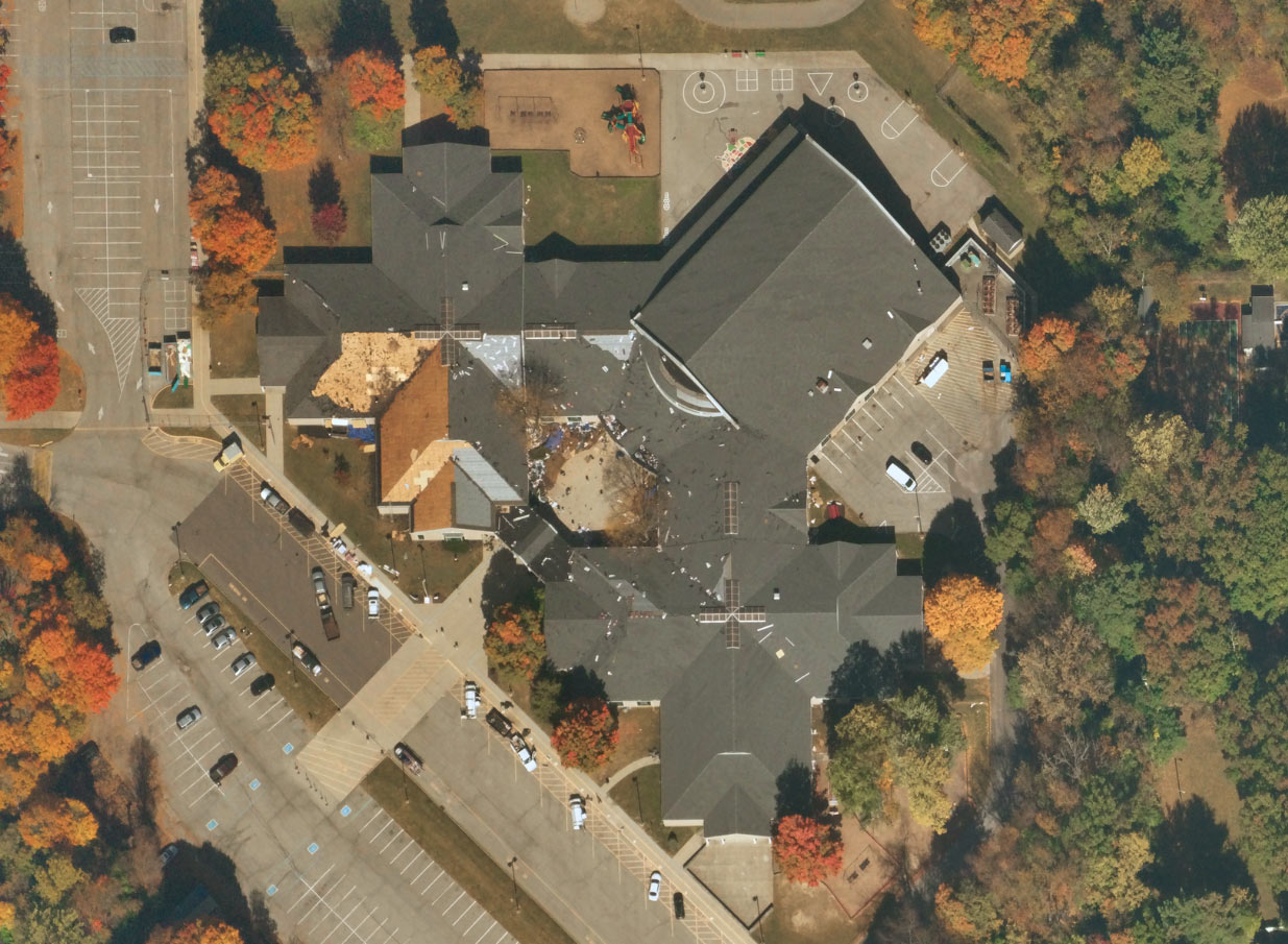 Near Space Labs' image of school in Indiana undergoing a roof replacement, surrounded by colorful green, yellow, and orange trees.