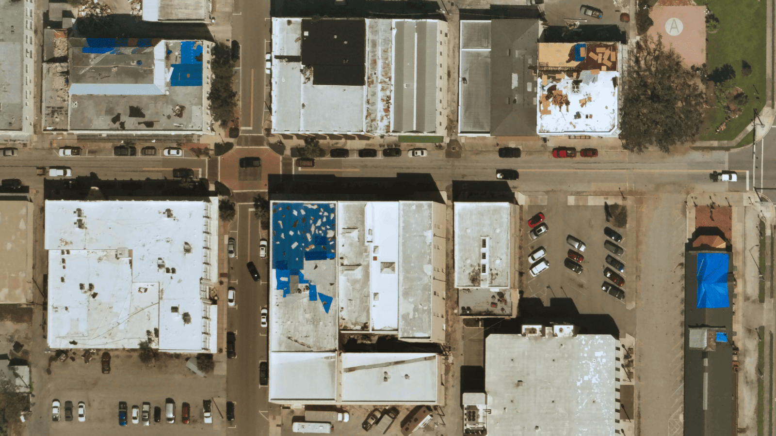Near Space Labs' imagery showing commercial buildings with damage to their roofs, some with blue tarps. 